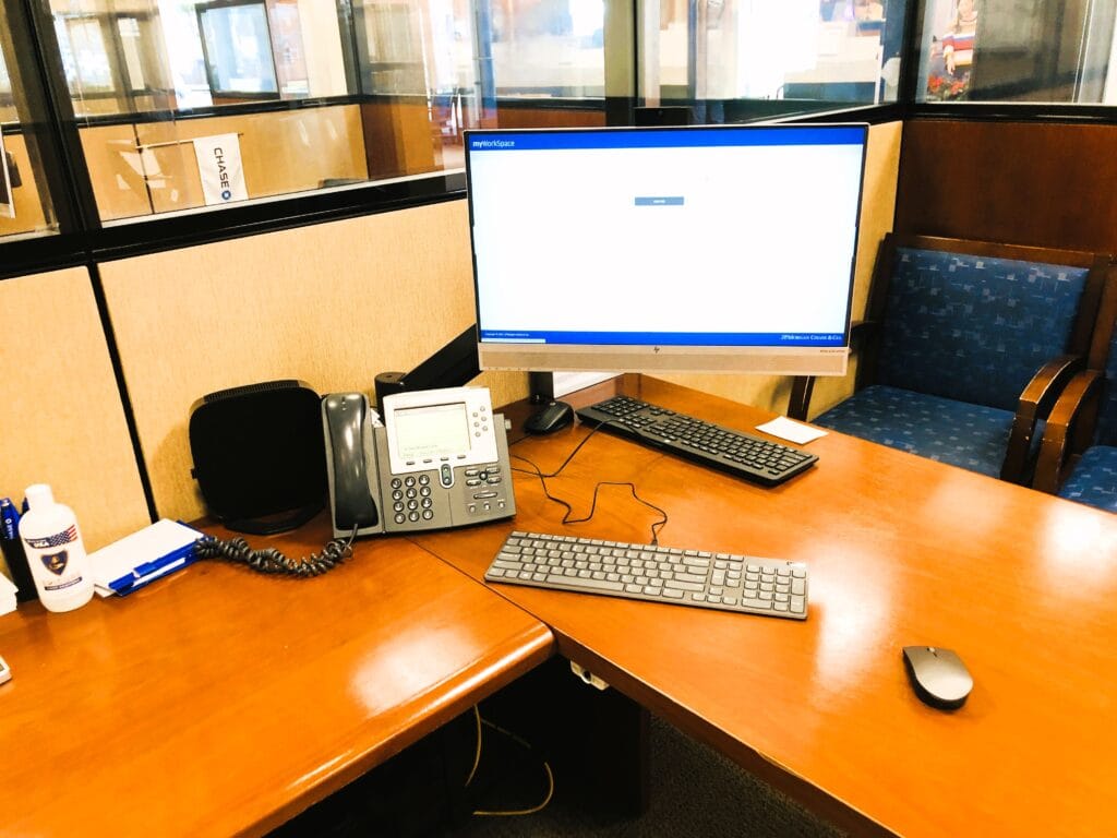 Branch desk with a workstation at a login screen beside a branded partition