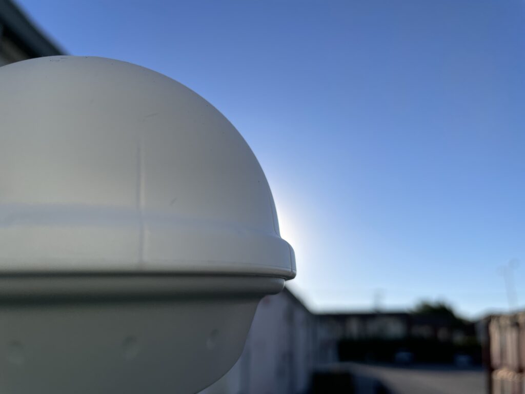 White dome antenna enclosure mounted against a clear blue sky