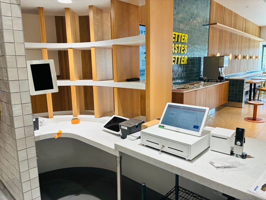 Restaurant counter under construction with a wall tablet, POS touchscreen, cash drawer and receipt printer