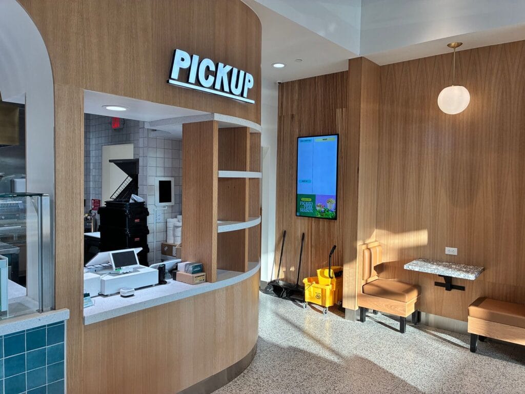 Pickup counter with a point of sale terminal below a digital menu screen